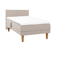 Beige Hilding Original -moottorisänky luonnonvärisillä 23 cm korkeilla Royal -tammijaloilla ja profiloidulla kimmovaahtosijauspatjalla. Kuvan sängynpääty ja tarviketasku myydään erikseen.
