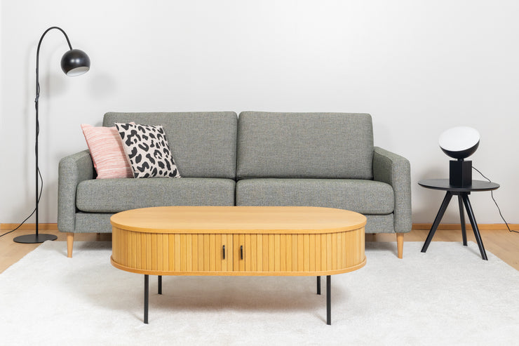 Kuvassa on oikealla musta Pod-poytavalaisin  mustan Yumi-sarjapöydän päällä ja vasemmalla Round Single -lattiavalaisin. Lisäksi kuvassa on Ilona 3h-sohva, Nola-sohvapöytä, valkoinen Louna-matto, sekä koristetyynyt Rita ja Kesalahti.