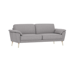 3-istuttava Ilona-sohva leveillä tyynyillä ja vaaleanharmaalla Otaru 300 -kangasverhoilulla. Kuvan sohvassa on 20 cm leveät KN20-käsinojat ja 18 cm korkeat puiset valkoiset pyöreäkartiojalat.