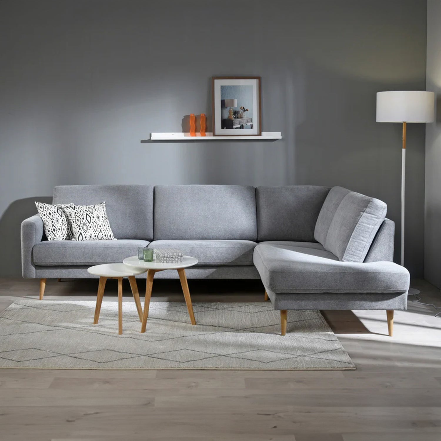 Kuvassa on Ilona-kulmadivaani vaaleanharmaalla Alfa 167 -kankaalla. Divaaniosa on edestä katsoen oikealla puolella. Kuvan sohvassa on 10 cm leveä KN10-käsinoja ja 18 cm korkeat suorat kartiojalat.