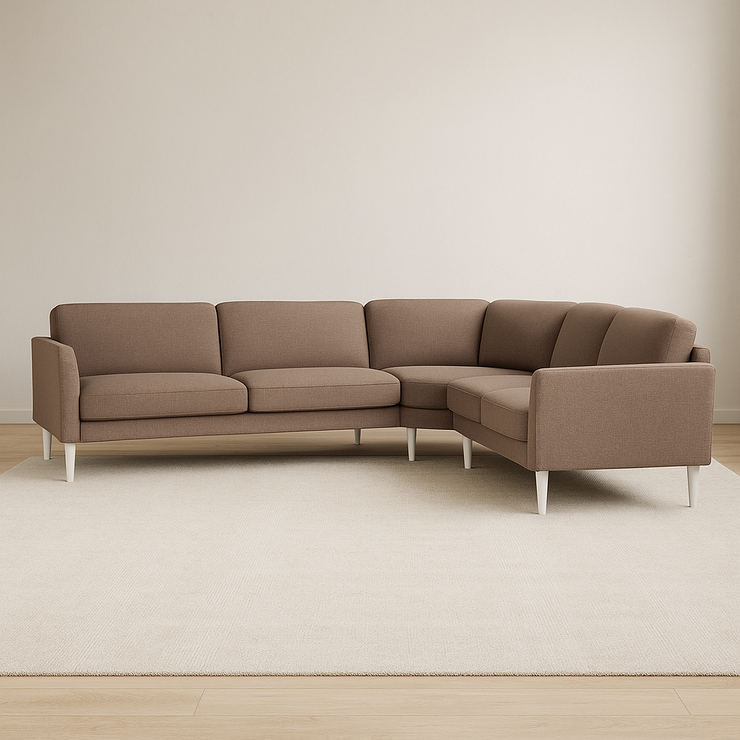 Ilona-kulmasohva tumman beigenvärisellä Barcelona 30 -kankaalla. Kuvan sohvassa on 15 cm leveät KNM15-käsinojat ja 18 cm korkeat valkoiset pyöreäkartiojalat. Stailattu visualisointi.