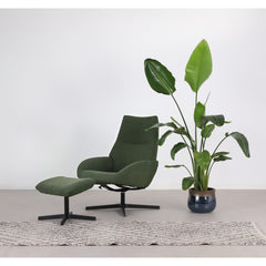 Kuvassa on Kebe Lotus -tv-tuoli ja rahi vihreällä Alpine Forest 438 -kangasverhoilulla ja mustalla Vision -ristikkojalalla. Settiin kuuluu optimaalisena jalkatukena toimiva rahi.