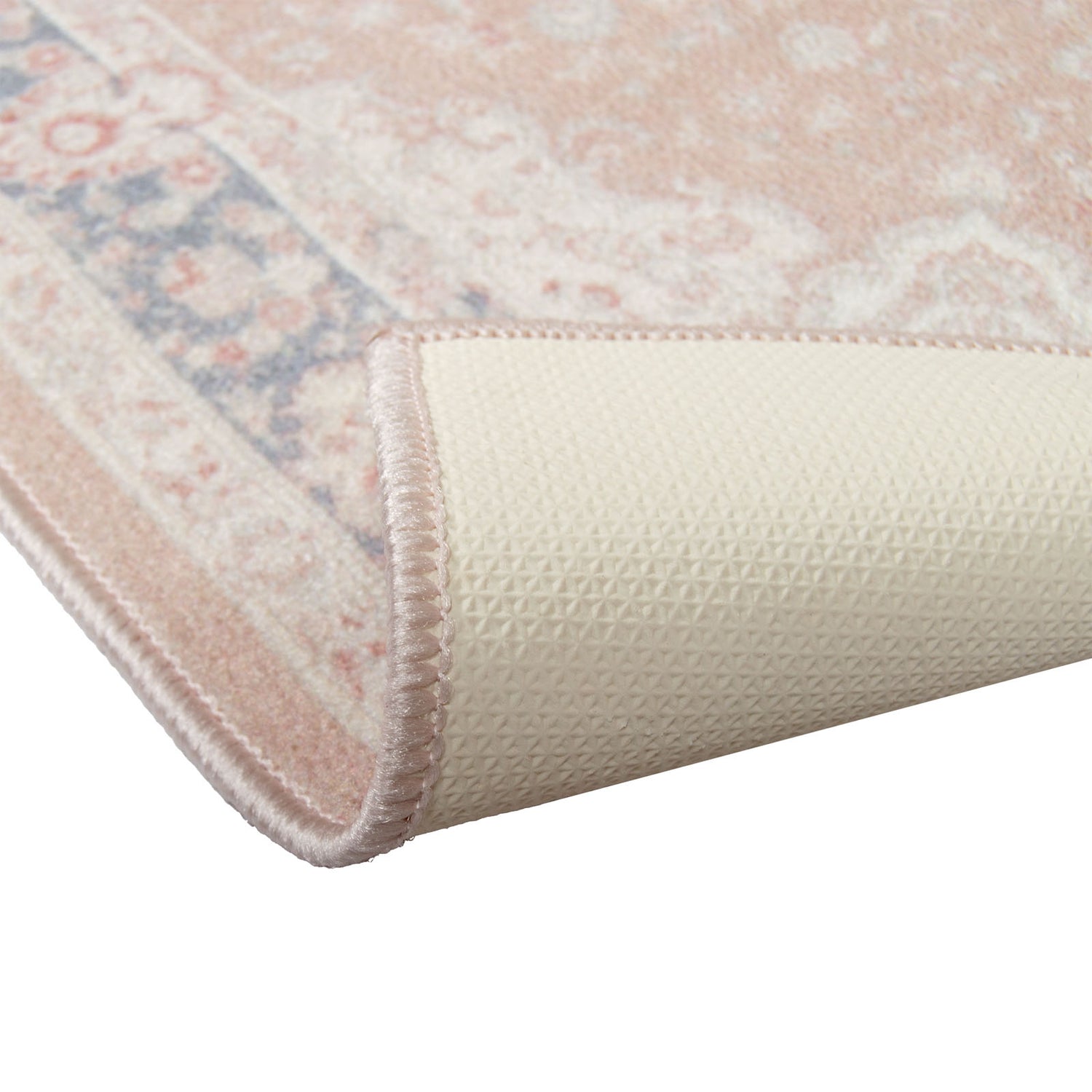 Sileäksikudotun Matilda-maton roosa väri yhdistää pehmeät roosan sävyt ja hienovaraisen sinisen vivahteen, joita  on tasapainottamassa lämmin beige pohja. Kuvassa näkyvissä maton kumipohjaus.