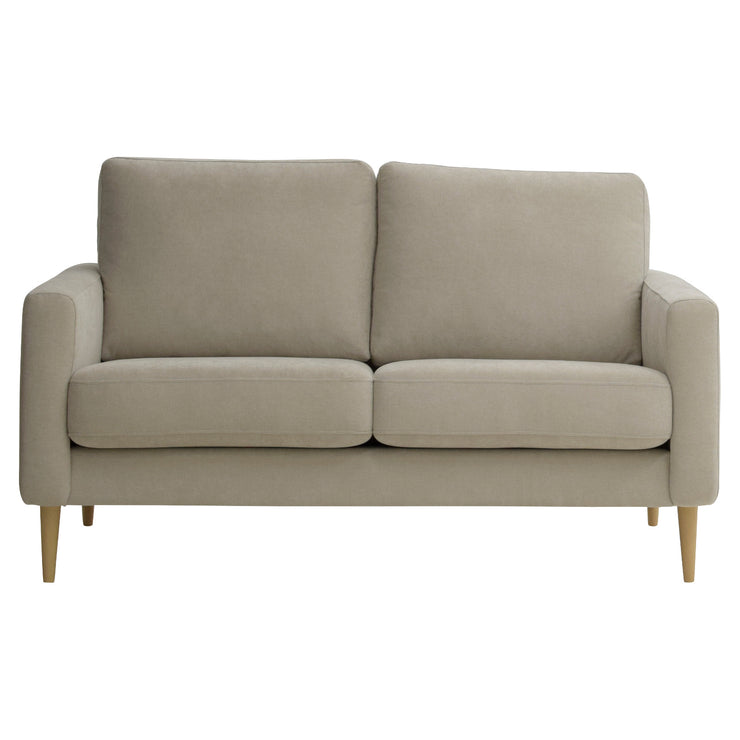 Kahden istuttava Mila-sohva hiekanväriselllä Feel 05 -kankaalla ja luonnonvärisillä pyöreäkartion mallisilla jaloilla.