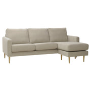 Kolmen istuttava Mila-divaanisohva oikeanpuoleisella divaanilla (kätisyys vaihdettavissa). Sohva on verhoiltu hiekanvärisellä Feel 05-kankaalla ja siinä on luonnonväriset pyöreäkartio-puujalat.