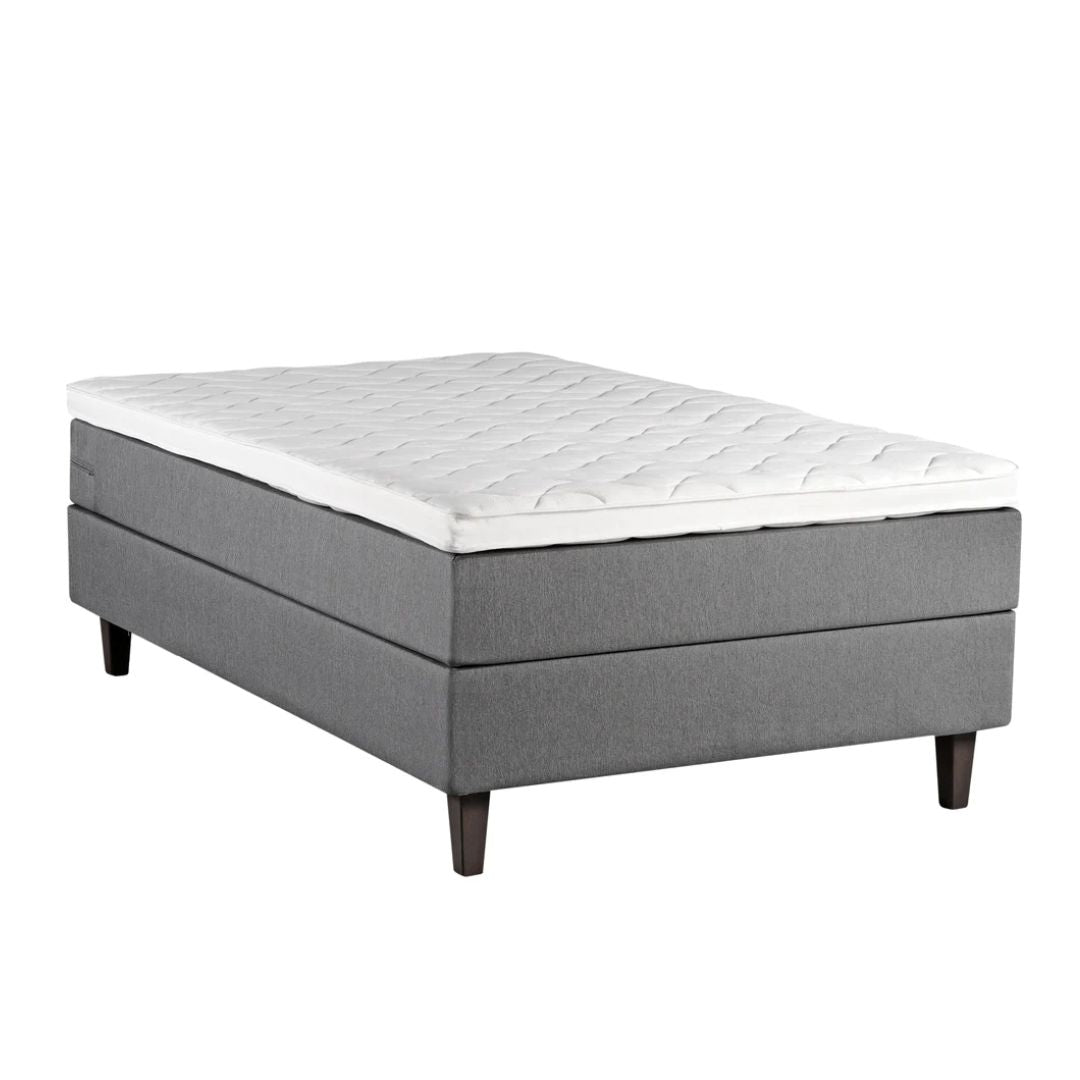 Harmaa Meri-jenkkisänky wengenvärisillä Royal-tammijaloilla ja profiloidulla sijauspatjalla.