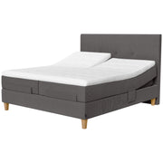 Jensen Onyx -säätösängyn harmaa Grey 173 verhoiluväri ja nelikulmaiset 23 cm korkeat luonnonväriset tammijalat. Erilliset TempSmart -sijauspatjat ja jalat sisältyvät hintaan. Kuvassa on myös erikseen myytävät split-mallinen ylhäältä halkaistu petauspatja, yhtenäinen verhoilu (4-jalalla) ja sängynpääty.