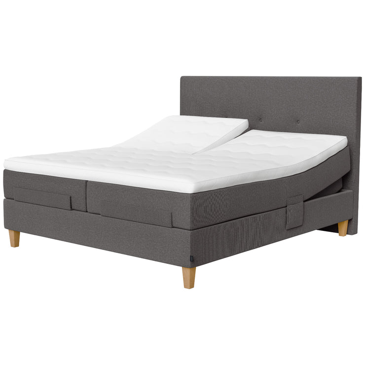 Jensen Onyx -säätösängyn harmaa Grey 173 verhoiluväri ja nelikulmaiset 23 cm korkeat luonnonväriset tammijalat. Erilliset TempSmart -sijauspatjat ja jalat sisältyvät hintaan. Kuvassa on myös erikseen myytävät split-mallinen ylhäältä halkaistu petauspatja, yhtenäinen verhoilu (4-jalalla) ja sängynpääty.