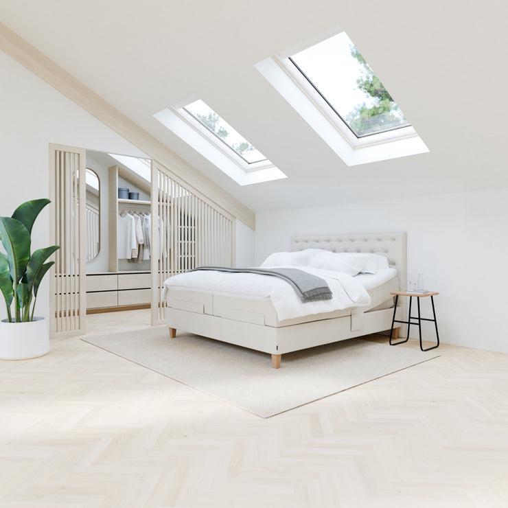 Kuvassa on Jensen Onyx -säätösängyn luonnonvaalea Natural 292 verhoiluväri ja nelikulmaiset 23 cm korkeat luonnonväriset tammijalat. Erilliset sijauspatjat ja jalat sisältyvät pakettiin, Diva-sängynpääty ja yhtenäinen alarunkojen Seamless-verhoilu myydään erikseen.