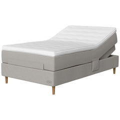 Jensen Opal -säätösängyn vaaleanharmaa Light Grey 186 -verhoilu ja luonnonväriset 14 cm korkeat Conic-tammijalat. Sijauspatja ja jalat sisältyvät hintaan.