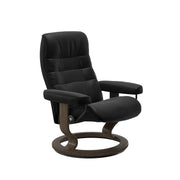 Stressless Opal M -lepotuoli mustana: Black 19 Batick-nahkaverhoilulla ja savutammi petsatulla -Classic-puujalustalla.