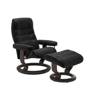 Stressless Opal M -lepotuoli ja rahi mustana: Black 19 Batick-nahkaverhoilulla ja wenge petsatulla -Classic-puujalustalla.