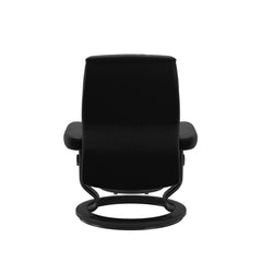 Stressless Opal M -lepotuoli ja rahi mustana: Black 19 Batick-nahkaverhoilulla ja musta petsi Black 05 -Classic-puujalustalla.