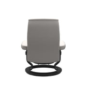 Stressless Opal M -lepotuoli ja rahi valkoisena: Milky White Batick-nahkaverhoilulla ja mustalla Black -Classic-puujalustalla.