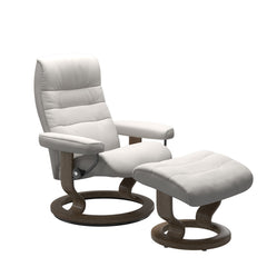 Stressless Opal M -lepotuoli ja rahi valkoisena: Milky White 05 Batick -nahkaverhoilulla ja savutammi petsatulla -Classic-puujalustalla.