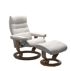 Stressless Opal M -lepotuoli ja rahi valkoisena: Milky White 05 Batick -nahkaverhoilulla ja tiikki petsatulla -Classic-puujalustalla.