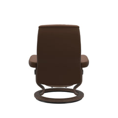 Stressless Opal M -lepotuoli ja rahi ruskeana: Warm Brown 87 Batick-nahkaverhoilulla ja pähkinä petsatulla -Classic-puujalustalla.