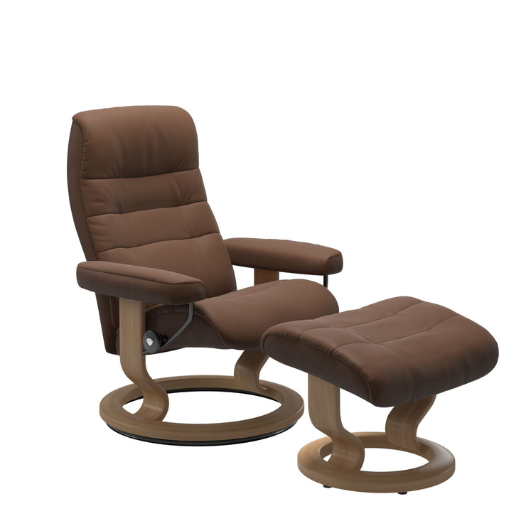 Stressless Opal M -lepotuoli ja rahi ruskeana: Warm Brown 87 Batick-nahkaverhoilulla ja tammi petsatulla -Classic-puujalustalla.