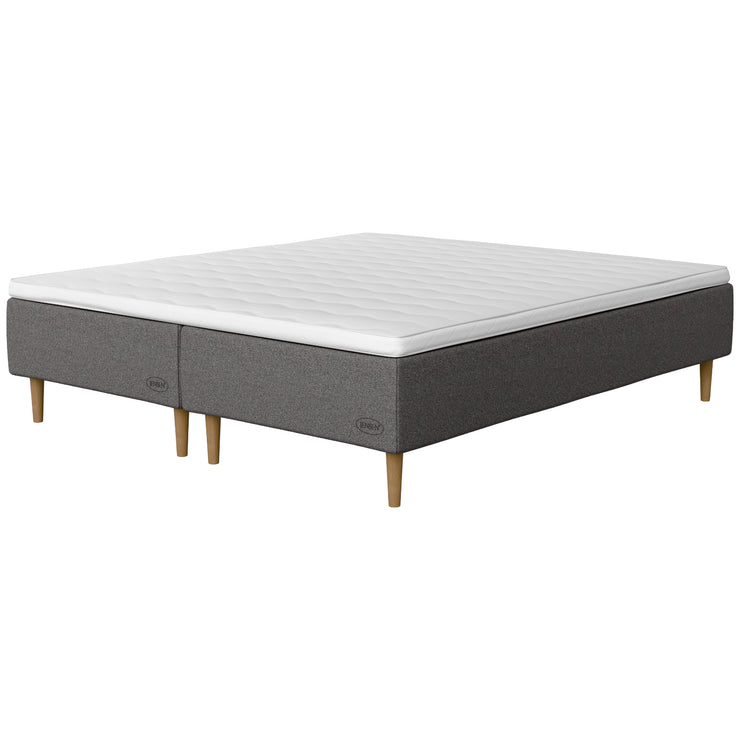 Jensen Opal -runkopatjasängyn harmaa Grey 187 -verhoilu ja luonnonväriset 23 cm korkeat Conic-tammijalat. Yhtenäinen sijauspatja ja jalat sisältyvät hintaan.