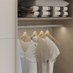 Kuvassa on mattavalkoinen Kira-liukuovikomero, toinen liukuovi avoinna. Kaapin sisus on väriltään harmaata kangasjäljitelmää.