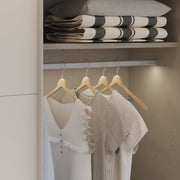 Kuvassa on mattavalkoinen Kira-liukuovikomero, toinen liukuovi avoinna. Kaapin sisus on väriltään harmaata kangasjäljitelmää.