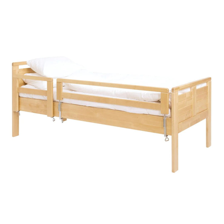 Seniori-sänky, johon on kiinnitetty turvalaita, sekä nousutuki (lyhyt).