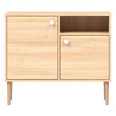 Tammenvärinen Stemma-lipastokaappi luonnonvärisillä tammijaloilla ja valkoisilla nuppivetimillä.