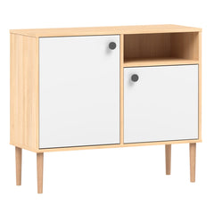 Tammi-valkoinen Stemma-lipastokaappi luonnonvärisillä tammijaloilla ja mustilla nuppivetimillä.