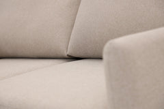 Lähikuvassa Stockholm Max Hybrid Deluxe 2-istuttava-vuodesohva beigellä Oasis 02 -kankaalla.