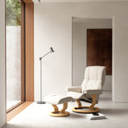 Stressless Mayfair -lepotuoli ja rahi valkoisena: Milky White 05 Batick-nahkaverhoilulla ja tammipetsatulla -Classic-puujalustalla.