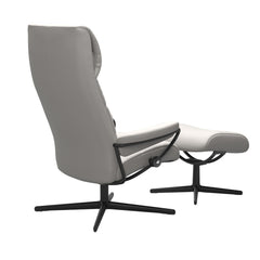 Stressless London, korkeaselkänojainen -lepotuoli ja rahi valkoisena: Milky White 05 Batick -nahkaverhoilulla ja mattamustalla Cross-metallijalustalla.