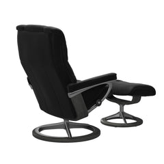 Stressless Mayfair M -lepotuoli ja rahi mustana: Black 19 Paloma-nahkaverhoilulla ja harmaa petsi 08 pyökki/kiiltävä alumiini Alu 40 -Signature-yhdistelmäjalustalla.