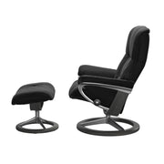 Stressless Mayfair M -lepotuoli ja rahi mustana: Black 19 Paloma-nahkaverhoilulla ja harmaa petsi 08 pyökki/kiiltävä alumiini Alu 40 -Signature-yhdistelmäjalustalla.