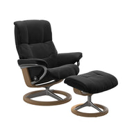 Stressless Mayfair M -lepotuoli ja rahi mustana: Black 19 Paloma-nahkaverhoilulla ja tammi petsi 04 pyökki/kiiltävä alumiini Alu 40 -Signature-yhdistelmäjalustalla.