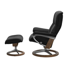 Stressless Mayfair M -lepotuoli ja rahi mustana: Black 19 Paloma-nahkaverhoilulla ja teak petsi 02 pyökki/kiillotettu alumiini Alu 40 -Signature-yhdistelmäjalustalla.