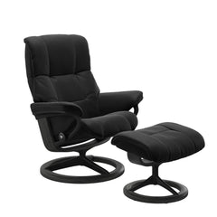 Stressless Mayfair M -lepotuoli ja rahi mustana: Black 19 Paloma-nahkaverhoilulla ja harmaa petsattu pyökki 08/mattamusta 45 metalli -Signature-yhdistelmäjalustalla.