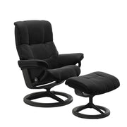 Stressless Mayfair M -lepotuoli ja rahi mustana: Black 19 Paloma-nahkaverhoilulla ja harmaa petsattu pyökki 08/mattamusta 45 metalli -Signature-yhdistelmäjalustalla.