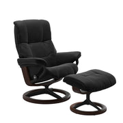 Stressless Mayfair M -lepotuoli ja rahi mustana: Black 19 Paloma-nahkaverhoilulla ja ruskea petsi 03/mattamusta 45 metalli -Signature-yhdistelmäjalustalla.