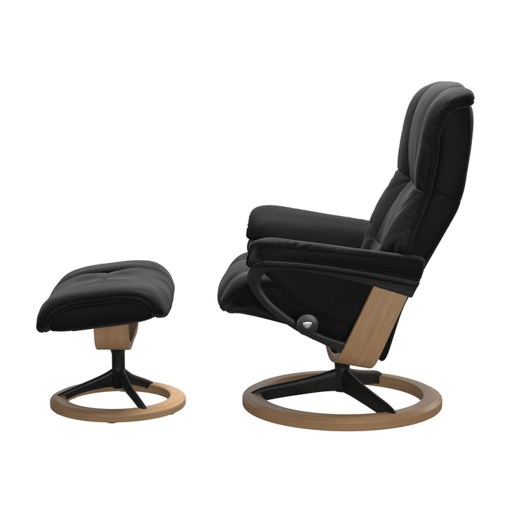 Stressless Mayfair M -lepotuoli ja rahi mustana: Black 19 Paloma-nahkaverhoilulla ja tammi petsi 04/mattamusta 45 metalli -Signature-yhdistelmäjalustalla.