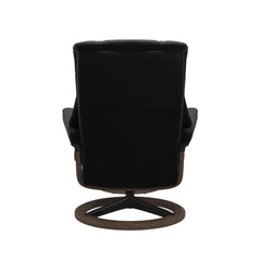 Stressless Mayfair M -lepotuoli ja rahi mustana: Black 19 Paloma-nahkaverhoilulla ja pähkinä petsi 06 pyökki/mattamusta 45 metalli -Signature-yhdistelmäjalustalla.