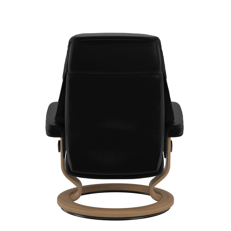 Stressless Ruby M -lepotuoli mustana: Black 19 Batick-nahkaverhoilulla ja tammi petsatulla -Classic-puujalustalla.