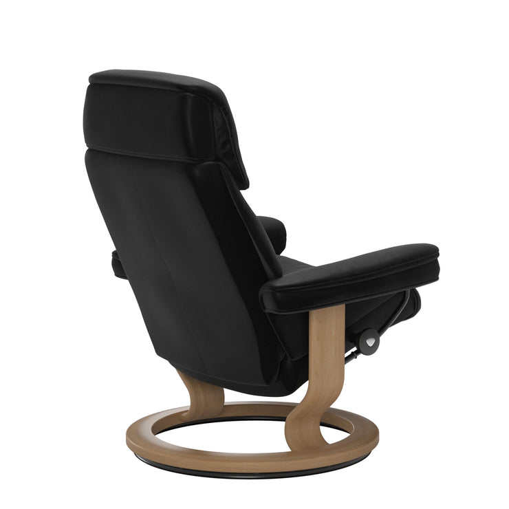 Stressless Ruby M -lepotuoli mustana: Black 19 Batick-nahkaverhoilulla ja tammi petsatulla -Classic-puujalustalla.
