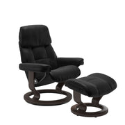 Stressless Ruby M -lepotuoli ja rahi mustana: Black 19 Batick-nahkaverhoilulla ja wenge petsatulla -Classic-puujalustalla.