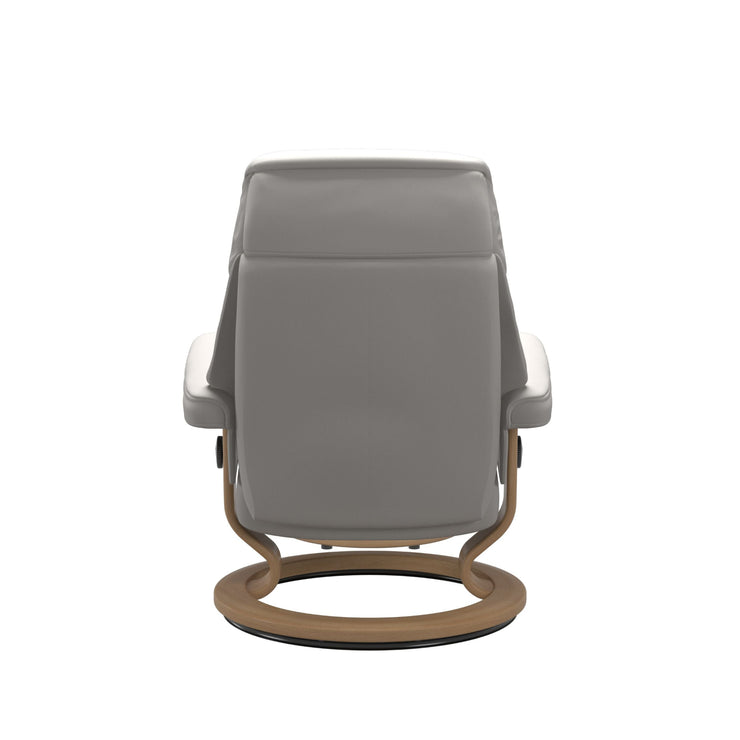 Stressless Ruby M -lepotuoli ja rahi valkoisena: Milky White 05 Batick-nahkaverhoilulla ja tammi petsatulla -Classic-puujalustalla.