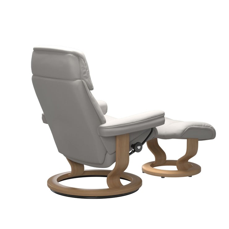Stressless Ruby M -lepotuoli ja rahi valkoisena: Milky White 05 Batick-nahkaverhoilulla ja tammi petsatulla -Classic-puujalustalla.