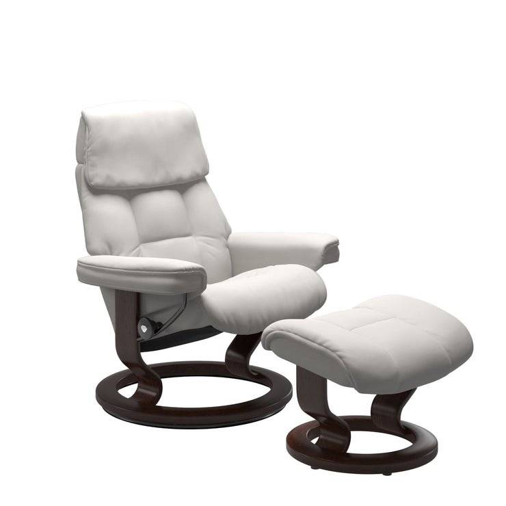 Stressless Ruby M -lepotuoli ja rahi valkoisena: Milky White 05 Batick-nahkaverhoilulla ja ruskea petsatulla -Classic-puujalustalla.