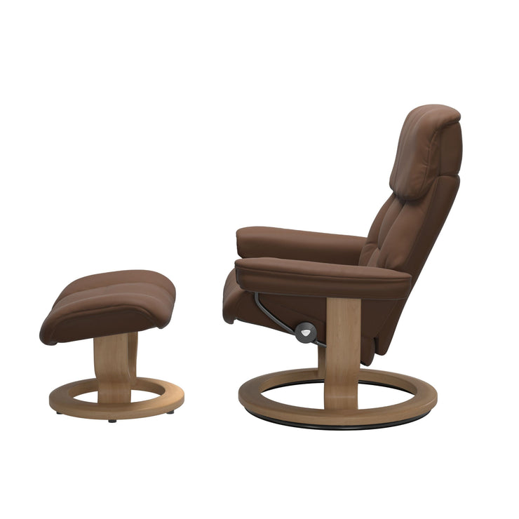 Stressless Ruby M -lepotuoli ja rahi ruskeana: Warm Brown 87 Batick-nahkaverhoilulla ja tammi petsatulla -Classic-puujalustalla.