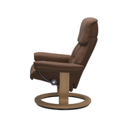 Stressless Ruby M -lepotuoli ruskeana: Warm Brown 87 Batick-nahkaverhoilulla ja tammi petsatulla -Classic-puujalustalla.