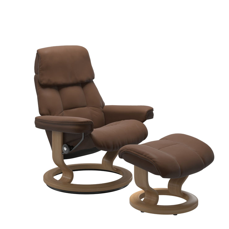 Stressless Ruby M -lepotuoli ja rahi ruskeana: Warm Brown 87 Batick-nahkaverhoilulla ja tammi petsatulla -Classic-puujalustalla.