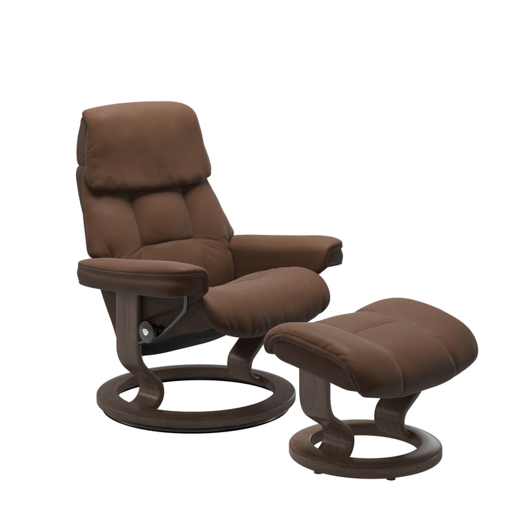 Stressless Ruby M -lepotuoli ja rahi ruskeana: Warm Brown 87 Batick-nahkaverhoilulla ja Walnut 06 petsatulla -Classic-puujalustalla.